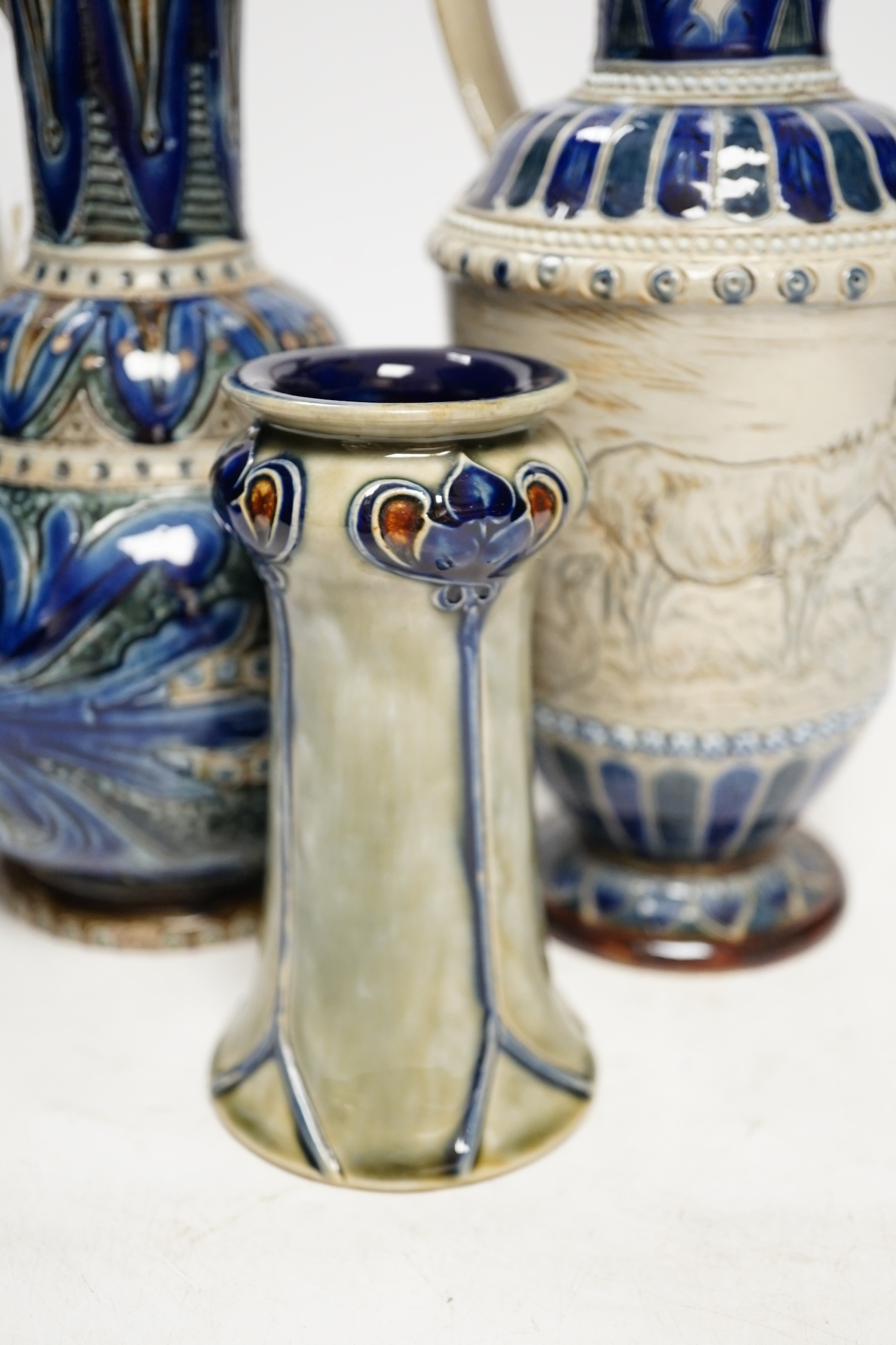 A Hannah Barlow for Doulton ‘geese and donkey’ jug, another jug dated 1874 and a small Royal Doulton vase, largest 24cm high. Condition - good